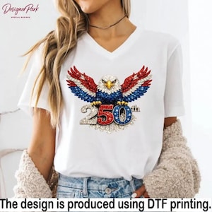 A woman wearing a white t-shirt with a graphic design of an eagle holding a flag with the number "250" on it.