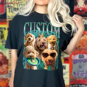 A woman wearing a black t-shirt with a graphic design featuring a group of dogs, including a golden retriever, a poodle, and a dachshund, all wearing sunglasses and holding a frisbee.