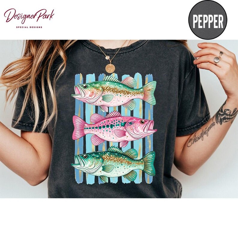 A person wearing a black t-shirt with a colorful graphic of three fish.