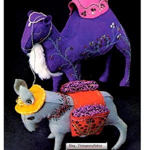 May include: A purple felt camel with a pink saddle and a gray felt donkey with a yellow hat and red saddlebags. Both animals are decorated with purple and gold embroidery and beads. The camel is 10 inches tall and the donkey is 6 inches tall. Super cute 10" Camel & 6" Little Italian Donkey Etsy: Vintagecraftsbox