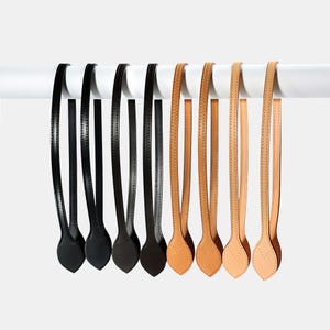 May include: A white ceramic mug with a black handle and the text "But First, Coffee" in a bold, black font. The mug is set against a blurred background, suggesting a cozy setting.