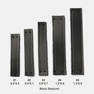 Peut inclure: Cinq lani&egrave;res rectangulaires noires en similicuir avec des coutures verticales et deux trous &agrave; chaque extr&eacute;mit&eacute;. Les lani&egrave;res sont num&eacute;rot&eacute;es de #1 &agrave; #5 avec des dimensions en cm : 0.9*4.5, 0.9*5.1, 0.9*5.7, 1.2*6.0 et 1.2*6.8. Texte Black Size(cm) en bas.