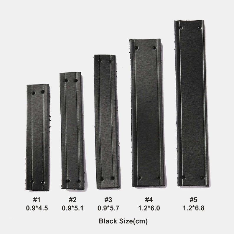 Peut inclure: Cinq lani&egrave;res rectangulaires noires en similicuir avec des coutures verticales et deux trous &agrave; chaque extr&eacute;mit&eacute;. Les lani&egrave;res sont num&eacute;rot&eacute;es de #1 &agrave; #5 avec des dimensions en cm : 0.9*4.5, 0.9*5.1, 0.9*5.7, 1.2*6.0 et 1.2*6.8. Texte Black Size(cm) en bas.