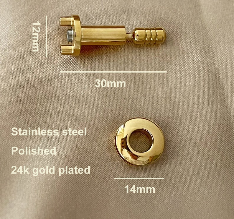 May include: A gold-plated, polished stainless steel  eyeglass screw with a 12 mm length and 30 mm diameter. The screw has a round head with a 14 mm diameter.