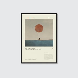 May include: A framed art print titled "Pendulum Man" featuring a minimalist landscape. The artwork depicts a large orange circle suspended above a small figure on a land mass, with text and a black frame.