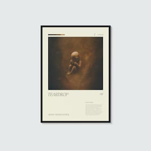 May include: A rectangular poster with a black frame featuring a central dark brown image of a fetus. The text reads TEARDROP, 98, A MINOR, and ARTIST: MASSIVE ATTACK. A small block of text is included below the title on a cream background.