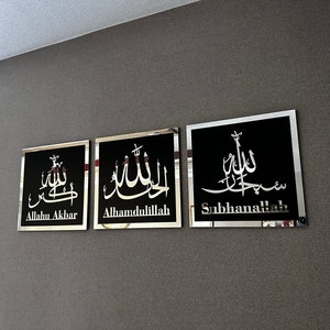 May include: Three framed black and silver wall decor pieces with Arabic calligraphy. The text reads "Allahu Akbar", "Alhamdulillah", and "Subhanallah".