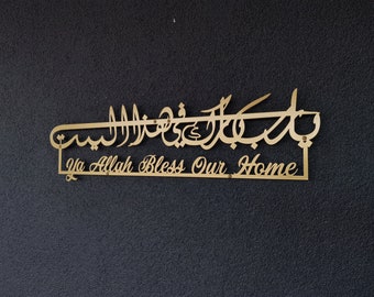 May include: A gold metal sign with Arabic calligraphy and the text "Ya Allah Bless Our Home".
