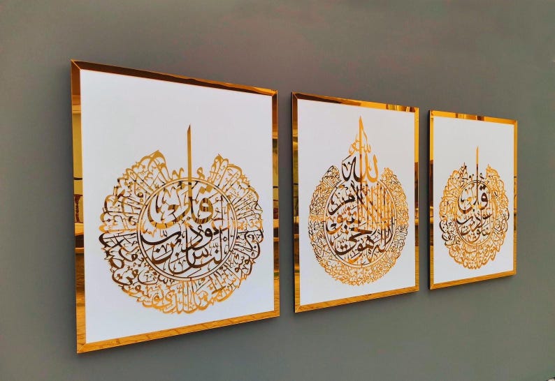 May include: Three framed art pieces with gold calligraphy on a white background. The gold frames and calligraphy create a luxurious look. The artwork is displayed on a gray wall.