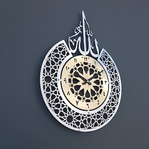 May include: A silver and gold clock with Arabic numerals and a geometric design. The clock face features the word "Allah" in Arabic calligraphy.