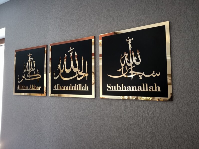 May include: Three gold framed wall plaques with black backgrounds and gold Arabic calligraphy. The plaques read "Allahu Akbar", "Alhamdulillah", and "Subhanallah".