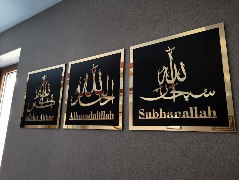 May include: Three square wall plaques with gold frames and black backgrounds. Each plaque features a different Arabic calligraphy inscription in gold. The inscriptions read "Allahu Akbar", "Alhamdulillah", and "Subhanallah".
