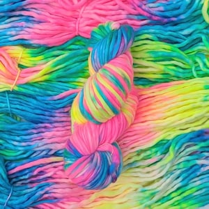 May include: A close-up of a skein of colorful yarn in shades of pink, blue, green, and yellow. The yarn is arranged in a loose, flowing pattern, creating a vibrant and textured image.
