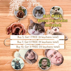 Puede incluir: Llaveros con fotos personalizadas con mascotas y personas. Los llaveros son de acrílico transparente con un llavero de metal. La imagen incluye un Golden Retriever, un gato y un Husky. Texto: "BUY MORE, Bonus Keychains Included!"