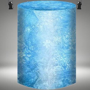 May include: A large, cylindrical, blue ice sculpture with a frosted, snowflake-like pattern.