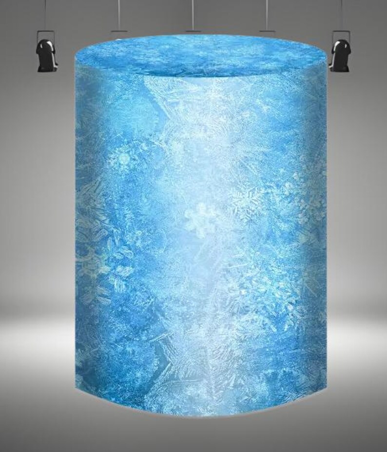 May include: A large, cylindrical, blue ice sculpture with a frosted, snowflake-like pattern.