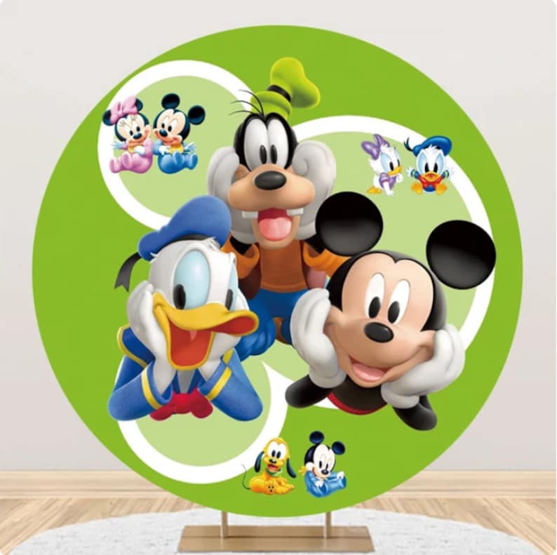 May include: A green circular backdrop with white outlines featuring Mickey Mouse, Minnie Mouse, Donald Duck, Goofy, and Pluto. The characters are smiling and looking at the viewer.