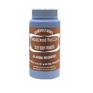 May include: A blue plastic jar with a copper label that reads "GRANDMASFARMUS Sandalwood Vanilla SILKY BODY POWDER ALL NATURAL PRESERVATIVES CORN FREE TALC FREE NON GMO PHTHALATE FREE Ingredients: Arrowroot Powder, Kaolin Clay, Aspen Bark Extract Essential or Fragrance Oil"