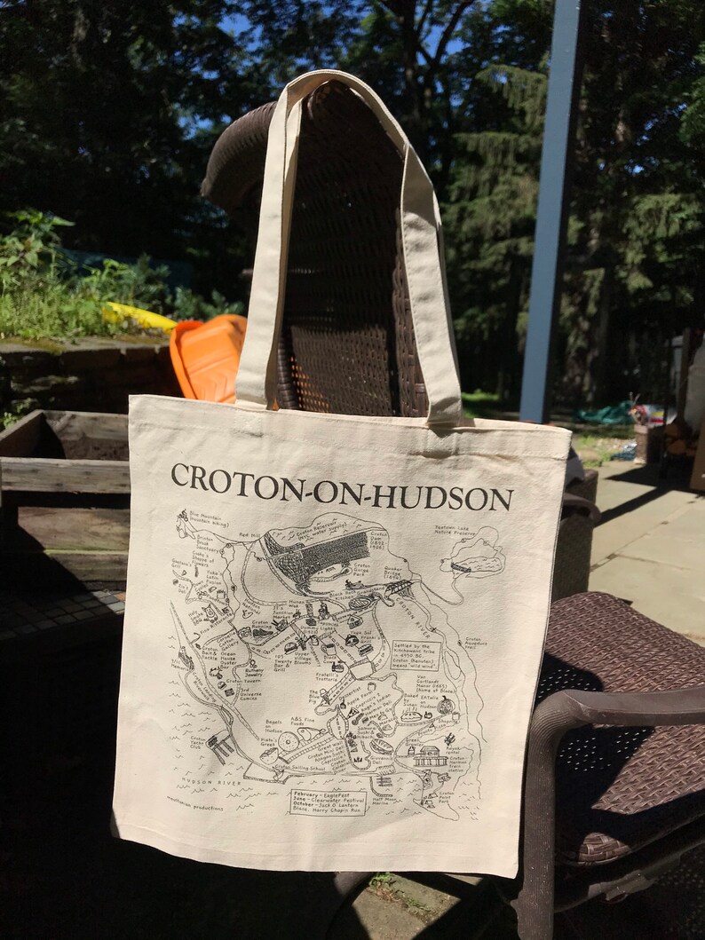K&ouml;nnte beinhalten: Eine wei&szlig;e Canvas-Tragetasche mit schwarzen Henkeln und einer schwarz-wei&szlig;en Karte von Croton-on-Hudson, New York. Die Karte zeigt verschiedene Sehensw&uuml;rdigkeiten und Punkte von Interesse, darunter das Croton Reservoir, der Croton Aqueduct und der Croton Point Park.