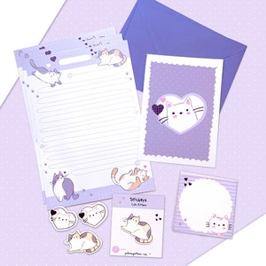 Puede incluir: Un juego de papelería con un tema lavanda e ilustraciones de gatos. El juego incluye papel rayado, una tarjeta de felicitación con un diseño de gato en forma de corazón, pegatinas y un sobre. Los artículos están dispuestos sobre un fondo punteado.