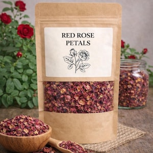 May include: A brown paper pouch labeled RED ROSE PETALS with a line drawing of a rose, containing dried red and pink rose petals visible through a clear window. A wooden bowl and spoon filled with the same dried petals sit in front.