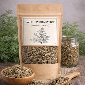 May include: A brown paper pouch containing dried Sweet Wormwood (Artemisia annua) with a clear window, a label featuring a botanical illustration, and the text The Blessed Gardens. The pouch is accompanied by a wooden bowl and spoon.