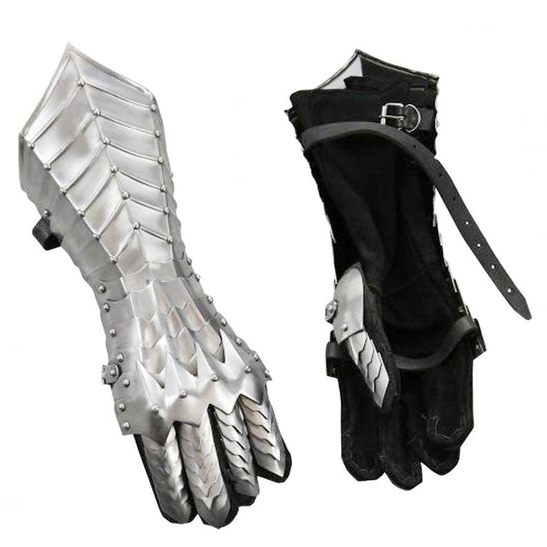 May include: A pair of silver metal gauntlets with a scale-like design. The gauntlets have a black leather strap with a buckle. The gauntlets are for the left and right hands.