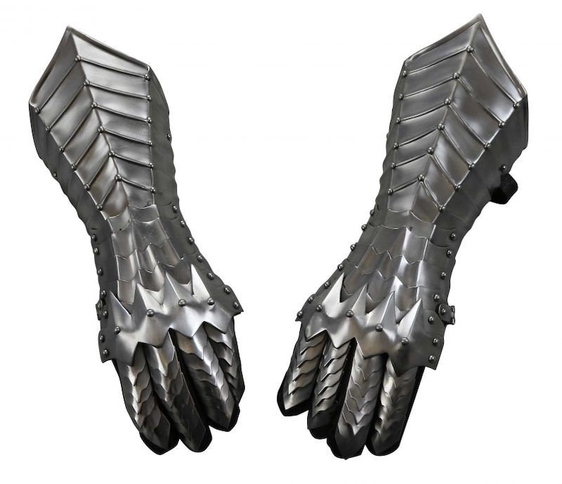 May include: A pair of silver metal gauntlets with a spiky design. The gauntlets are made of interlocking plates and have a pointed finger design.