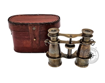 Könnte beinhalten: Antikes Messingfernglas mit einer braunen Ledertragetasche. Das Fernglas hat ein klassisches Design mit einstellbarem Fokus und eine Vintage-Ästhetik. Die Tasche ist oval und hat einen Knopfverschluss.