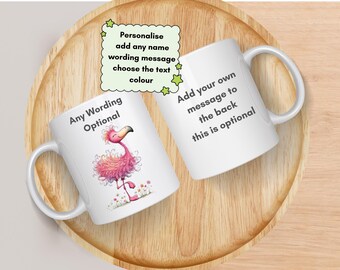 Pode incluir: Duas canecas de cerâmica branca com uma ilustração de flamingo rosa e texto preto. Uma caneca exibe Any Wording Optional, enquanto a outra mostra Add your own message to the back this is optional. Uma nota verde diz Personalise add any name wording message choose the text colour.