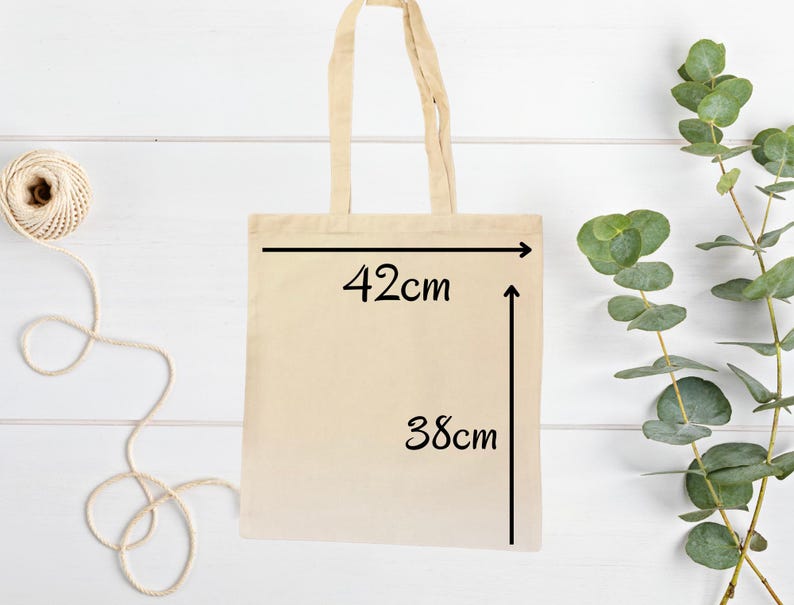 以下が含まれることがあります： ベージュのキャンバス地のトートバッグで、黒い文字で「42cm」と「38cm」と書いてあり、バッグのサイズを示しています。