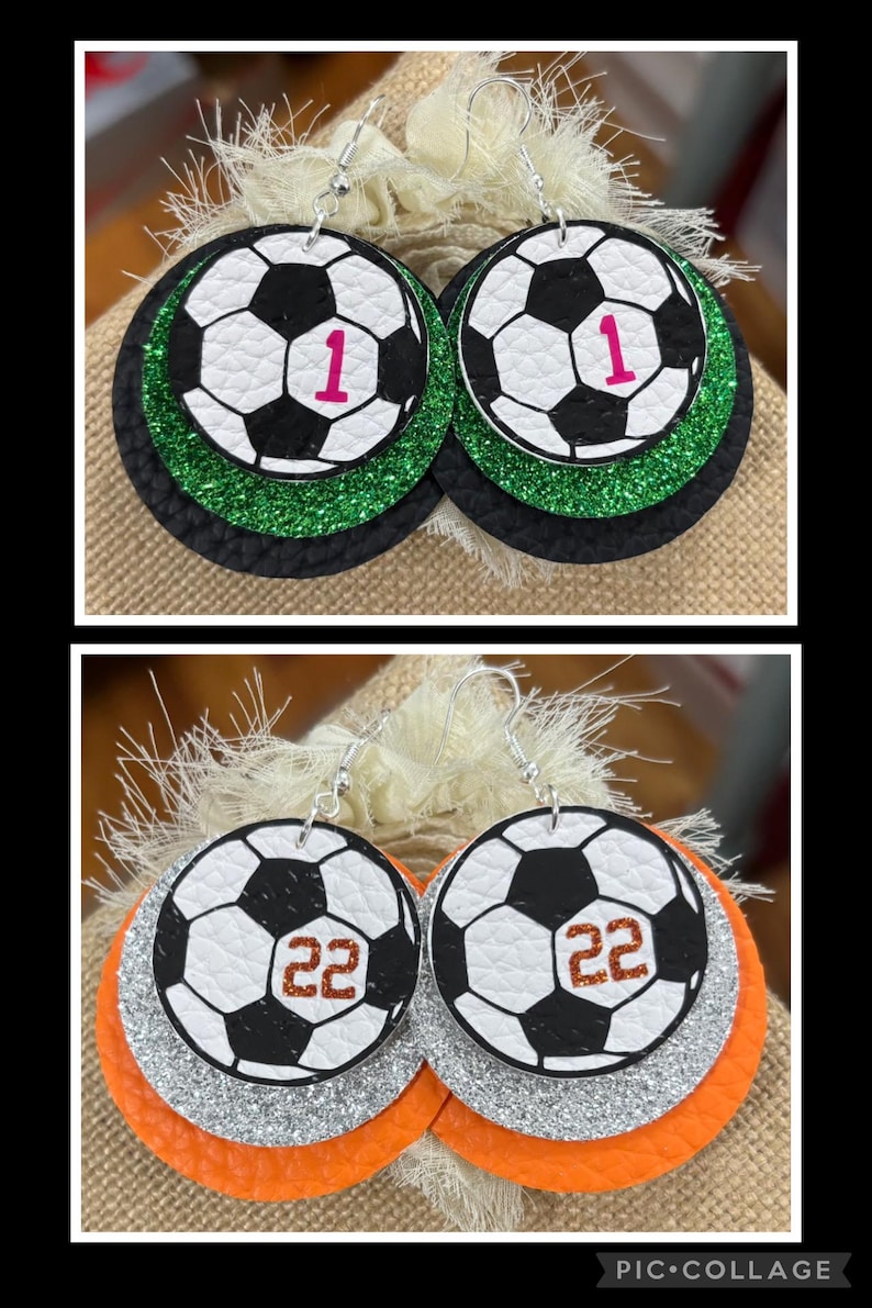 May include: Soccer ball earrings with a black and white design, featuring the number 1 in pink and the number 22 in brown. The earrings have layers of black, green, silver, and orange glitter.
