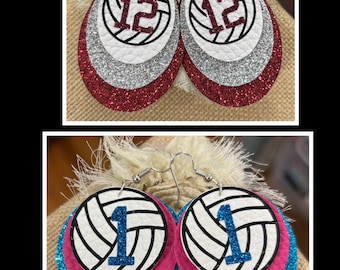 Könnte beinhalten: Zwei Paar geschichtete Ohrringe. Das obere Paar hat Tropfenformen mit weißen Volleyballgrafiken, der Zahl 12 in dunkelrotem Glitzer, silbernem Glitzer und roten Glitzerschichten. Das untere Paar hat Kreisformen mit weißen Volleyballgrafiken, der Zahl 1 in blauem Glitzer, pinken und blauen Glitzerschichten.