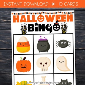 May include: Halloween Bingo game with 10 cards. The bingo card has a 3x3 grid with images of a candy corn, cauldron, spider, pumpkin, skull, ghost, candy, and bat.