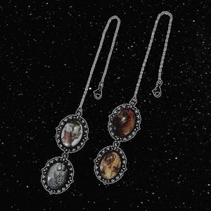 May include: Two silver chains with three oval-shaped pendants each. The pendants feature vintage-style images of people and objects.