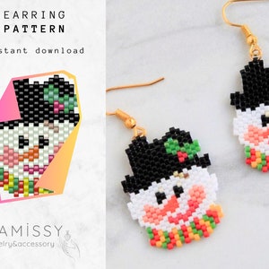 May include: A pair of beaded snowman earrings with black hats, white faces, orange noses, and green and red scarves. The earrings are made with seed beads and are attached to gold ear wires. The image also includes the text "EARRING PATTERN Instant download" and "DiAmissy jewelry&accessory".