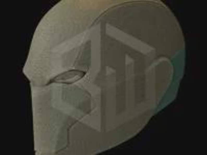 May include: A matte gray helmet with a smooth, textured surface. The helmet features a visor area and ear coverings with a hint of teal. The design suggests a futuristic or cosplay theme.