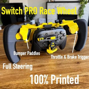 May include: A black and yellow Switch PRO Race Wheel controller accessory featuring bumper paddles, throttle and brake triggers, and full steering capabilities. The device is labeled with text including Switch PRO Race Wheel and 100% Printed.
