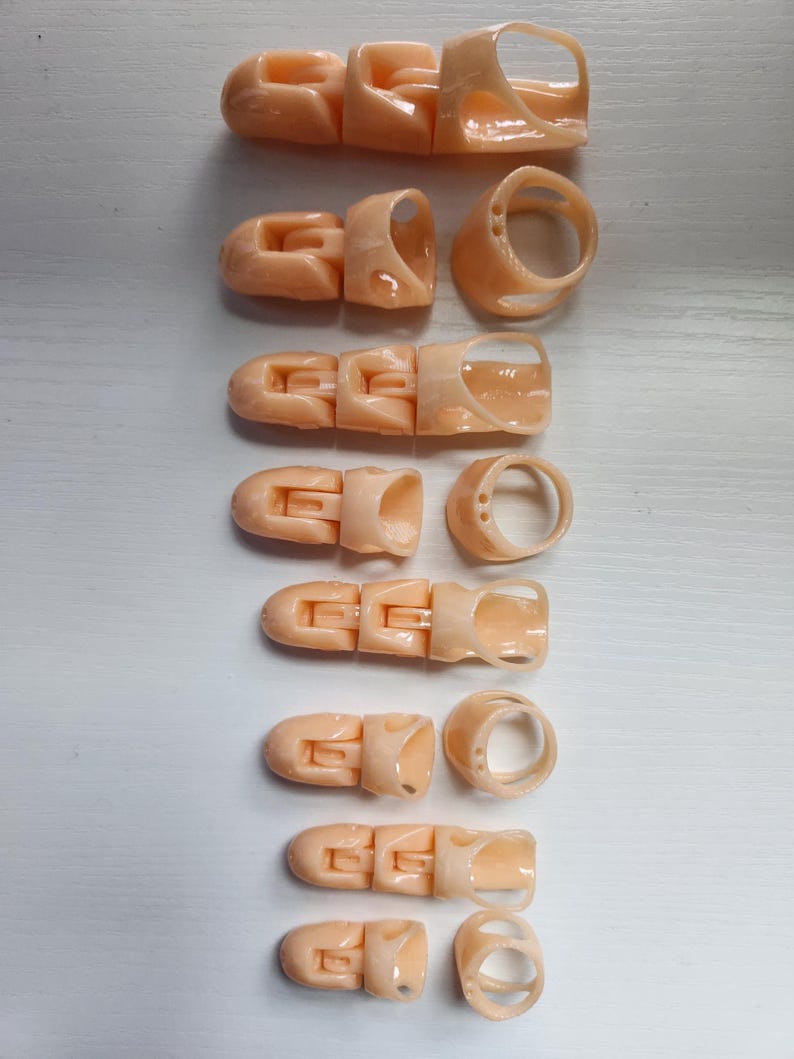 May include: Set of ten beige plastic finger splints, each with a different size and shape. The splints are designed to support and protect injured fingers.
