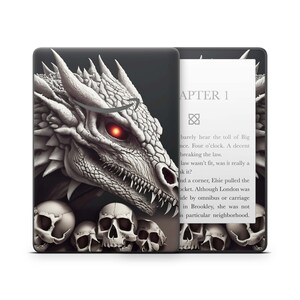 Könnte beinhalten: Eine schwarz-weiße E-Reader-Hülle mit einem detaillierten Drachenkopf mit leuchtend rotem Auge und Totenkopfmotiv. Die offene Hülle zeigt den Text "CHAPTER 1" auf dem Bildschirm.