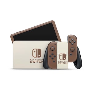 Könnte beinhalten: Eine braune und weiße Nintendo Switch Konsole mit zwei passenden Controllern. Die Konsole und die Controller haben ein herzförmiges Design mit dem Nintendo Switch Logo.