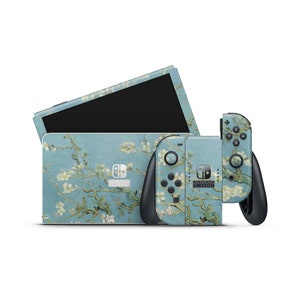 Könnte beinhalten: Eine Nintendo Switch-Konsole und Joy-Con-Controller mit einer benutzerdefinierten Haut, die ein Gemälde eines blauen Himmels mit weißen Blüten zeigt. Die Haut ist mit "Nintendo Switch" beschriftet.