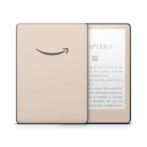 Könnte beinhalten: Ein beiger Kindle E-Reader mit dem Amazon-Logo auf der Vorderseite. Der Bildschirm zeigt den Text "APTER 1" und einen Absatz Text an.