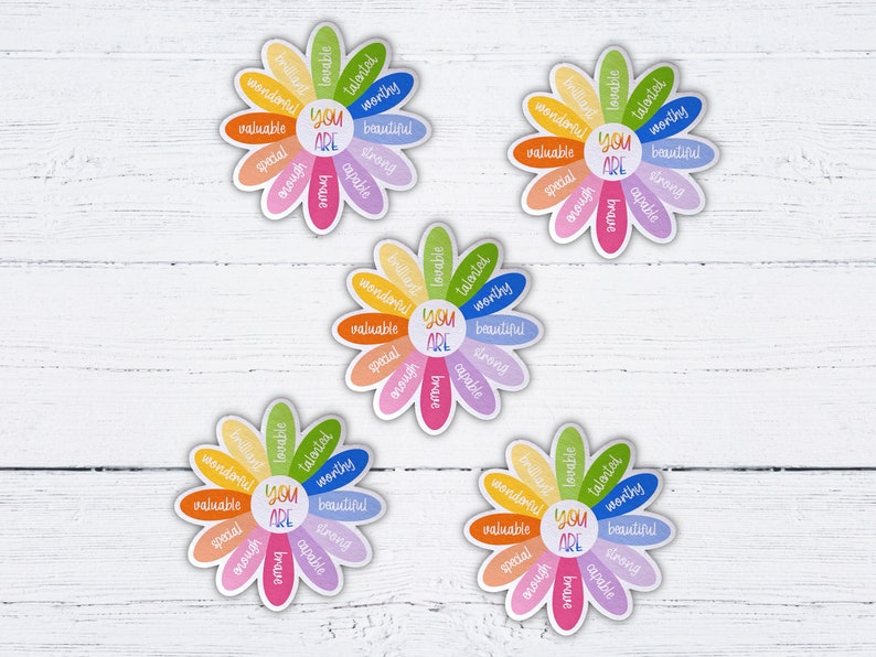 Pu&ograve; includere: Quattro adesivi colorati a forma di margherita con le parole "You Are" al centro e affermazioni positive intorno ai petali. Le affermazioni includono parole come "amabile", "talentuoso", "degno", "bello", "speciale", "forte", "capace", "coraggioso", "abbastanza", "meraviglioso" e "prezioso".
