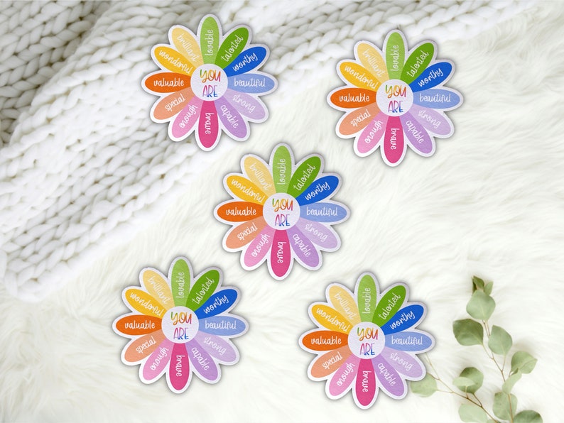 Pu&ograve; includere: Quattro adesivi colorati a forma di fiore con il testo "You Are" al centro e affermazioni positive intorno ai petali. Le affermazioni includono parole come "amabile", "talentuoso", "degno", "bello", "speciale", "forte", "coraggioso", "capace", "abbastanza", "meraviglioso" e "prezioso".