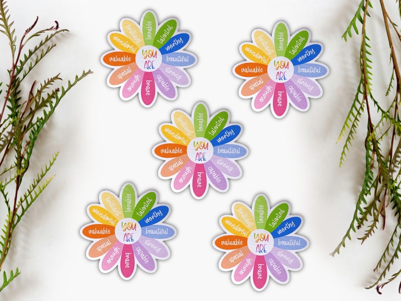 Pu&ograve; includere: Quattro adesivi colorati a forma di fiore con le parole "You Are" al centro e affermazioni positive intorno ai petali. Le affermazioni includono parole come "amabile", "talentuoso", "degno", "bello", "forte", "capace", "speciale", "abbastanza", e "coraggioso".