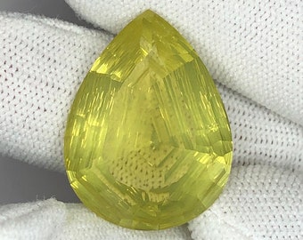 May include: A pear-shaped, faceted, yellow gemstone with a clear, glassy finish.