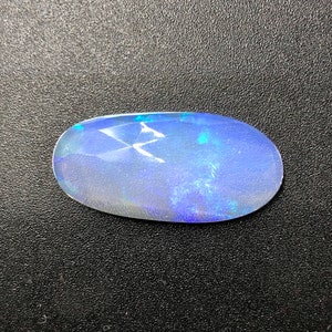 May include: A blue oval opal gemstone with iridescent flashes of color.