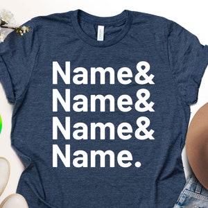 May include: A navy blue t-shirt with the text "Name & Name & Name & Name." printed in white. The shirt is shown on a white background with a pair of white shoes, a brown hat, and blue jeans.