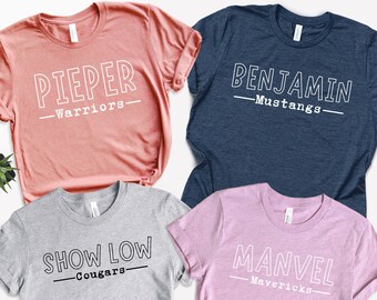 May include: Four t-shirts with different names and team names printed on them. The shirts are in different colors: pink, gray, blue, and coral.
